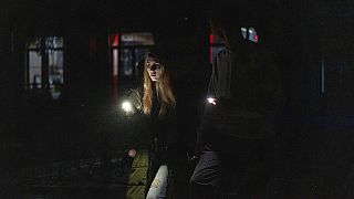 Una joven pareja camina en el centro de la ciudad que se quedó sin energía eléctrica tras el ataque ruso con cohetes de ayer en Kiev, Ucrania, 24/11/2022