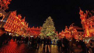 Visitors stand in front of the illuminated Christmas tree at the Winter Wonder and Christmas Market on the Grand Place in Brussels, Belgium, Nov. 25, 2022.