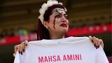 هوادار تیم فوتبال ایران با در دست گرفتن پیراهنی با نام مهسا امینی در بازی ایران و ولز