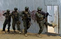 جنود ملثمون من الجيش الوطني الصومالي يفتشون في المنازل بحثاً عن مقاتلين من حركة الشباب ، خلال عملية في إيلشا بياها. 2012/06/02