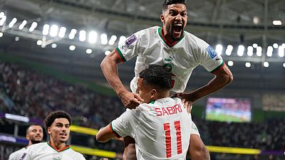 Morocco's Yahya Jabrane, top, celebrates with Abdelhamid Sabiri (11) after Sabiri scored during the World Cup match against Belgium in Doha, Nov. 27, 2022.