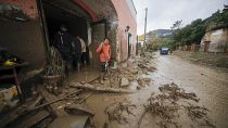 Unas personas se paran frente a una tienda inundada en Casamicciola, en la sureña isla italiana de Ischia, el sábado 26 de noviembre de 2022.