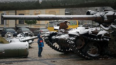 طفل ينظر للدبابات الروسية والمدرعات المدمرة بعد تساقط الثلوج في وسط مدينة كييف - أوكرانيا. 2022/11/17