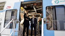 French President Emmanuel Macron (L) inspects a RER A train