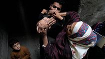 یک کارمند بهداشت واکسن فلج اطفال را در محله‌ای از لاهور پاکستان، به کودکی می‌خوراند