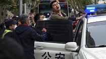 In this photo taken on Sunday, Nov. 27, 2022, a protester reacts as he is arrested by policemen during a protest on a street in Shanghai, China. 
