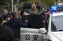 Un manifestant embarqué de force par les forces de l'ordre à Urumqi, en Chine