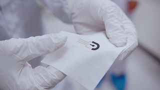 Lab technician holds the SmartHEAL bandage, a device that can monitor how a wound is healing without removing the dressing.