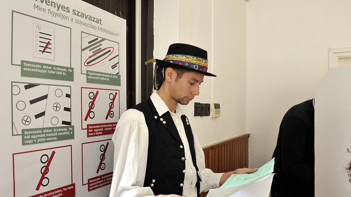 Egy szlovák nemzetiségű lakos a szavazólapot olvassa Pilisszentkereszten a nemzetiségi szavazókörben 2014-ben