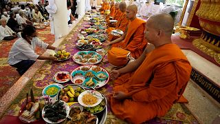 بستگان قربانیان یک حمله کشتار جمعی برای جمع کردن فضیلت به راهبان بودایی غذا می دهند.