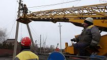 Trabalhadores reparam linhas elétricas na região de Donetsk, Ucrânia.