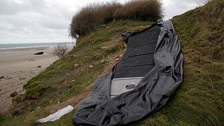 A damaged inflatable small boat is pictured on the shore in Wimereux, northern France.