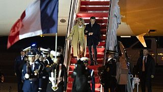 Emmanuel Macron et son épouse à leur descente de l'avion mardi soir. 