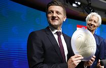 Croatia's ex-Finance Minister Zdravko Maric holds up a cardboard euro coin after a signing ceremony for Croatia to join the euro in Brussels, Tuesday, July 12, 2022.