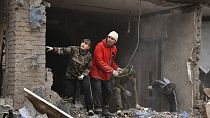 Az emberek azon dolgoznak, hogy eltávolítsák a törmeléket egy oroszok által bombázott házból Szlovjanszkban 2022. október 10-én