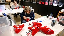Des employés fabriquent des peluches représentant la mascotte "Phryges" des Jeux olympiques et paralympiques de Paris 2024 dans l'atelier de Doudou et Compagnie