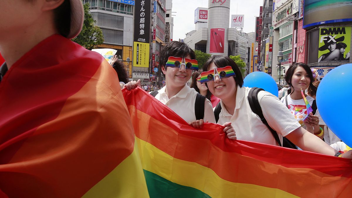 Participants smile as they march with a banner during the Tokyo Rainbow Pride parade celebrating the LGBT community in Tokyo.