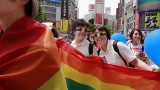 Participants smile as they march with a banner during the Tokyo Rainbow Pride parade celebrating the LGBT community in Tokyo.