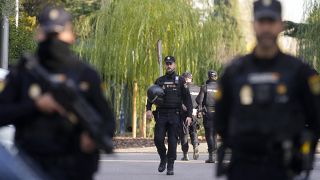 Police officers stand guard near the Ukrainian embassy, located in Madrid's Piovera neighbourhood.