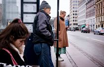 Passengers at a bus stop in Copenhagen, Denmark, Tuesday, Feb. 1, 2022.
