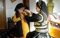 Μητέρα ετοιμάζει την κόρη με την παραδοσιακή φορεσιά για τον Τρανό χορό