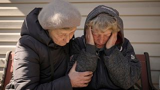 A neighbour comforts Natalia Vlasenko, whose husband, Pavlo Vlasenko, and grandson, Dmytro Chaplyhin, called Dima, were killed by Russian forces in Bucha.