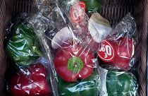 Peppers wrapped in plastic package are on display on a grocery stall in Paris, Friday, Dec. 31, 2021.
