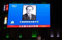 صورة الرئيس الصيني الراحل جيانغ تسه مين على شاشة كبيرة في أحد مراكز التسوق في بكين، الأربعاء 30 نوفمبر 2022