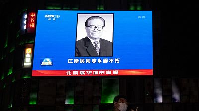 صورة الرئيس الصيني الراحل جيانغ تسه مين على شاشة كبيرة في أحد مراكز التسوق في بكين، الأربعاء 30 نوفمبر 2022