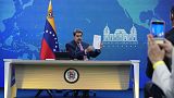 El presidente venezolano Nicolás Maduro sostiene un documento relacionado con el reinicio de las conversaciones entre su gobierno y la oposición, el 30 de noviembre de 2022.