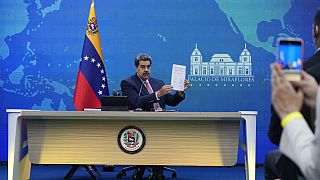 El presidente venezolano Nicolás Maduro sostiene un documento relacionado con el reinicio de las conversaciones entre su gobierno y la oposición, el 30 de noviembre de 2022.