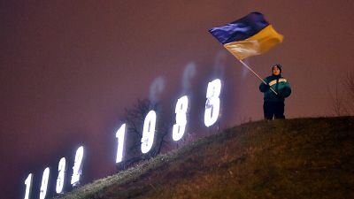 Украинский флаг на фоне инсталляции в память о жертвах Голодомора в Украине