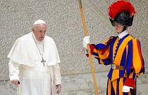 Pope Francis walks past a Swiss Guard as he arrives to meet with members of the Italian Schools for Peace Network at the Vatican, Monday, Nov. 28, 2022.
