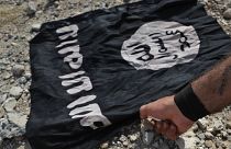 علم داعش قبل حرقه في الرقة شمال شرق سوريا.
