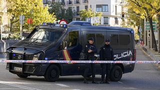 Police officers stand guard as they cordon off the area next to the U.S. embassy in Madrid, Spain, Thursday, Dec. 1, 2022
