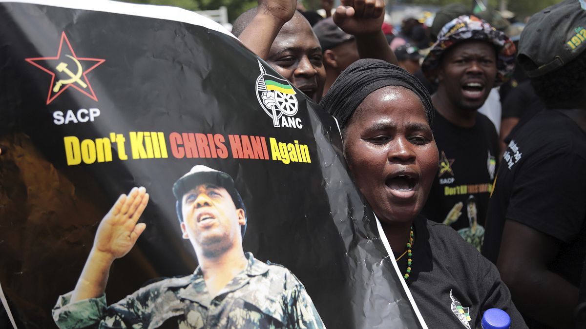 "Chris Hani'yi bir daha öldürme" yazılı pankart tutan protestocular