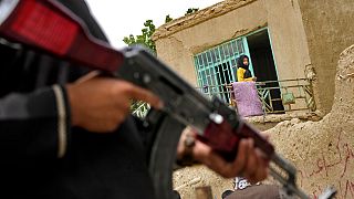 A Taliban fighter stands guard at the site of an explosion in front of a school in Kabul, Afghanistan, on April 19, 2022.