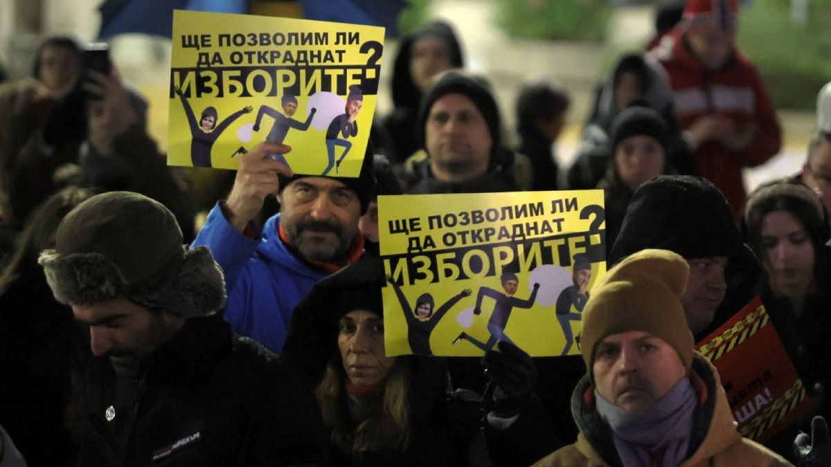Protesters hold posters that read: "Will we allow them to steal our vote?" as hundreds of Bulgarians gather in front of Bulgarian Parliament on Thursday, Dec. 1, 2022.