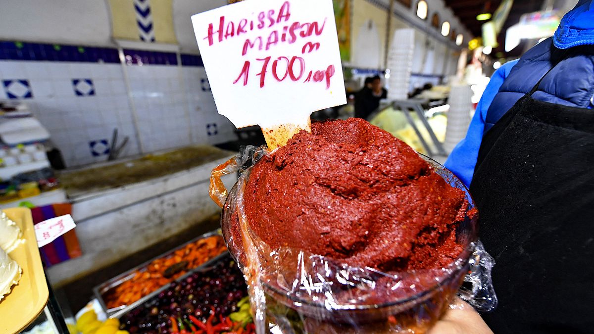 A shopkeeper shows a plate of Tunisian Harissa at the central market of the capital Tunis on December 1, 2022. 