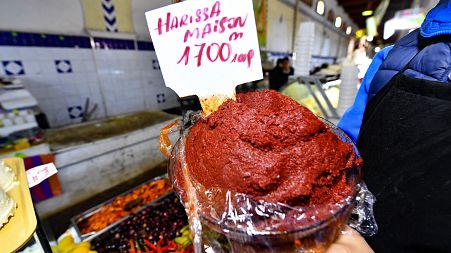 A shopkeeper shows a plate of Tunisian Harissa at the central market of the capital Tunis on December 1, 2022.