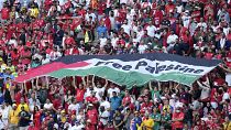 مشجعون يرفعون علمًا كتب عليه "فلسطين حرة" خلال مباراة كأس العالم بين تونس وأستراليا في الدوحة. 