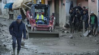Workers clear mud and debris from a street in Casamicciola.