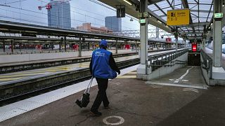 An employee walks along an empty platform at Lyon Part-Dieu railway station.