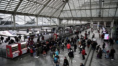 Commuters wait in line to take the train at Gare de Lyon in Paris.