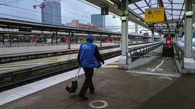 An employee walks along an empty platform at Lyon Part-Dieu railway station.