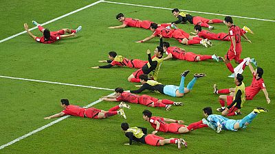 Jogadores sul-coreanos atiraram-se para o relvado a comemorar a vitória sobre Portugal e a passagem aos oitavos