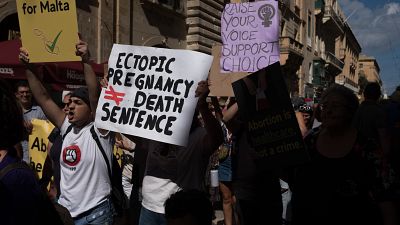 Protesters carry placards and walk through Valletta's streets during an abortion rights rally on September 25, 2022 in Valletta, Malta. 