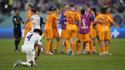 Tyler Adams of the United States knees down on the pitch at the end of the World Cup round of 16 match agains the Netherlands in Doha, 3 December 2022