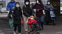 Maszkot viselő járókelők Pekingben 2022. december 2-án