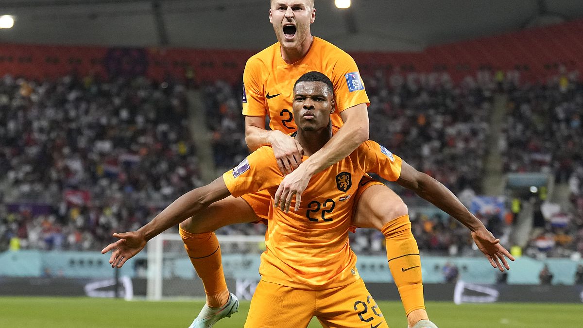 Denzel Dumfries of the Netherlands, bottom, is congratulated after scoring his side's 3rd goal during the World Cup round of 16 soccer match between the Netherlands and the US